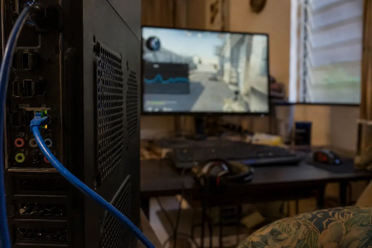 Cable Ethernet conectado al PC mientras una partida muestra variaciones de latencia