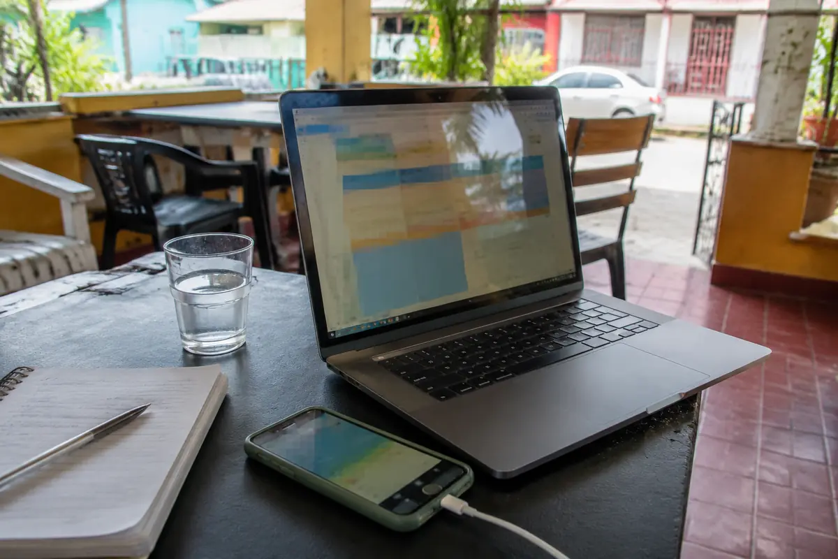 Portátil de trabajo junto a un teléfono usado como hotspot en una terraza de Puerto Rico