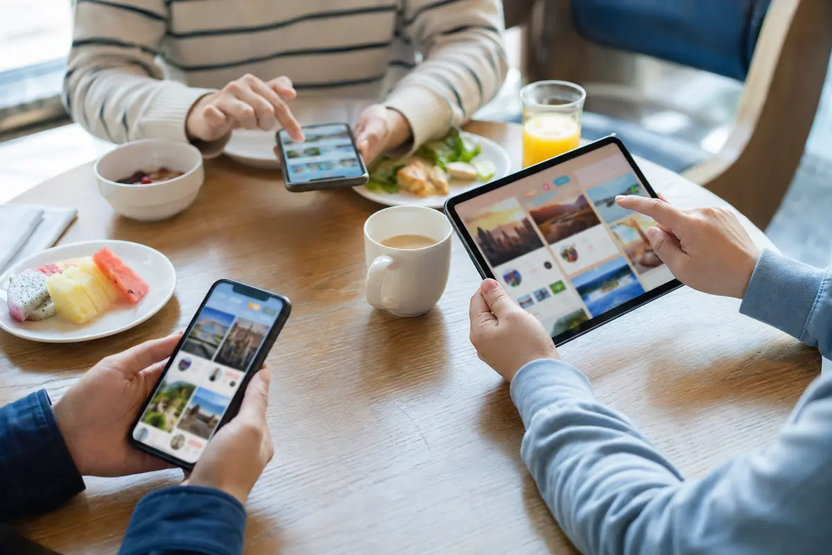 Au petit-déjeuner, trois membres d’une famille utilisent simultanément deux téléphones et une tablette désormais connectés