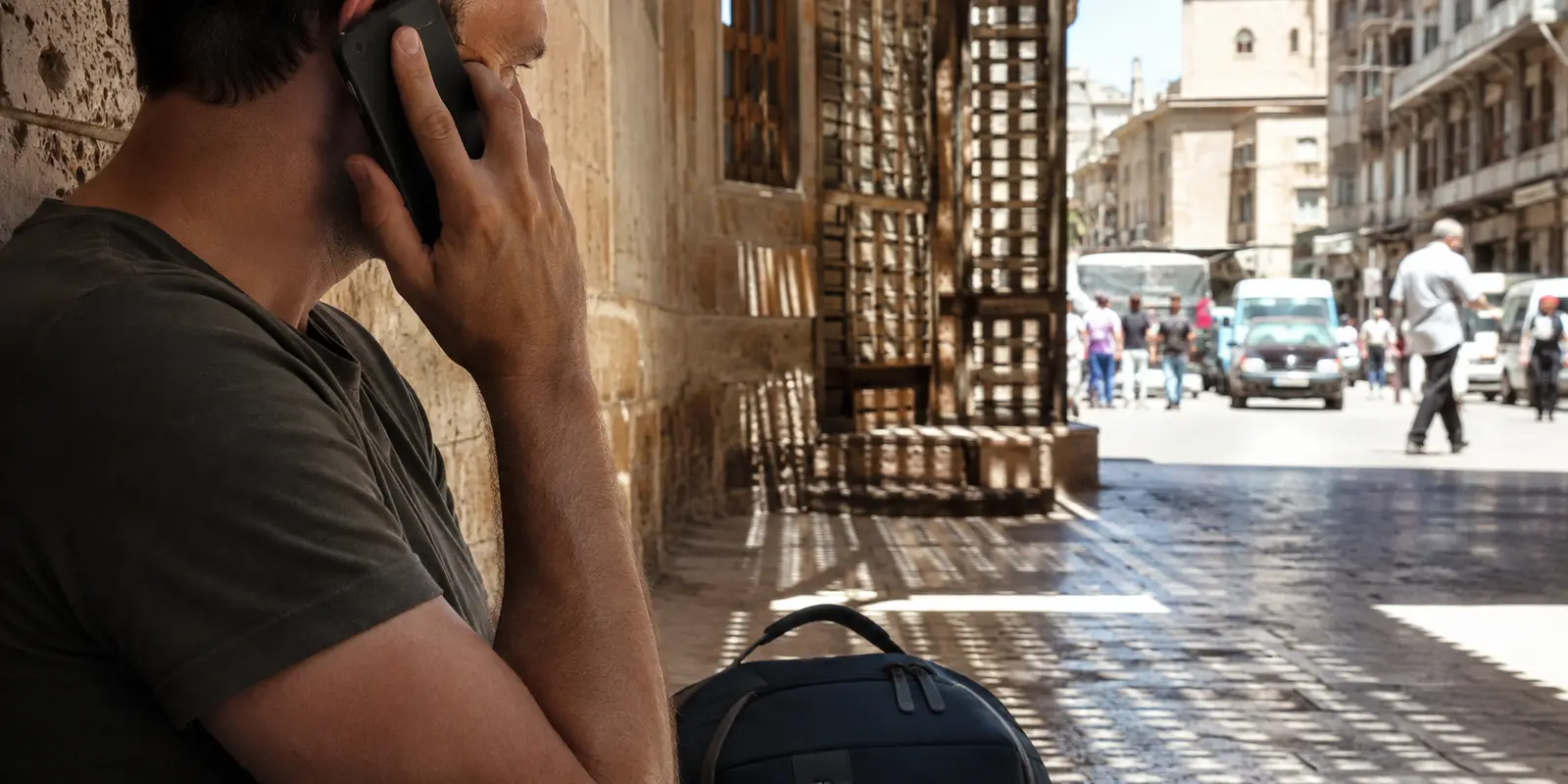 Un voyageur tente un appel sur son téléphone dans un passage ombragé du Caire