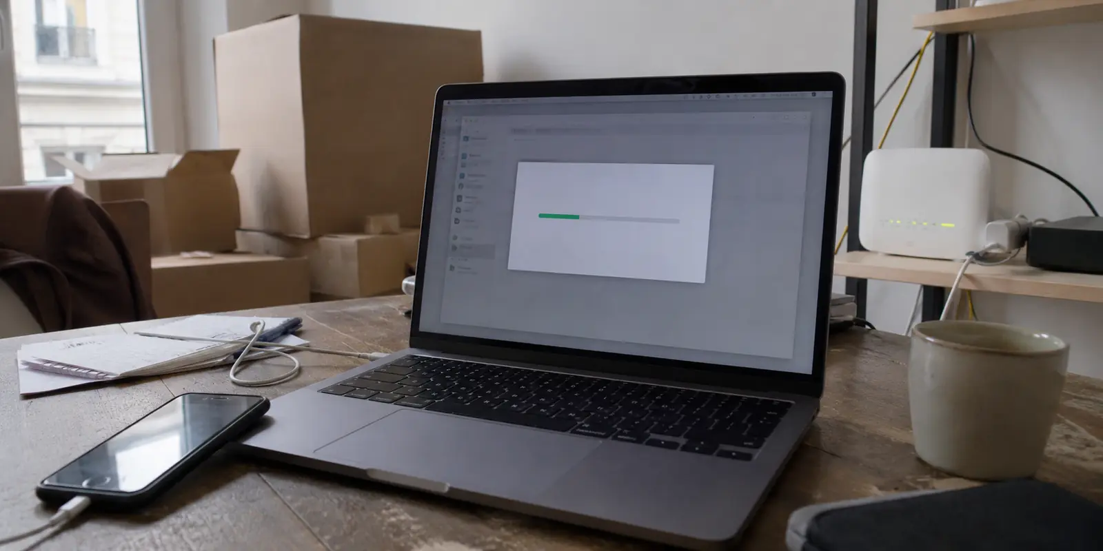 Un transfert de fichiers bloqué sur un ordinateur relié à une nouvelle box fibre, avec le téléphone encore posé à côté
