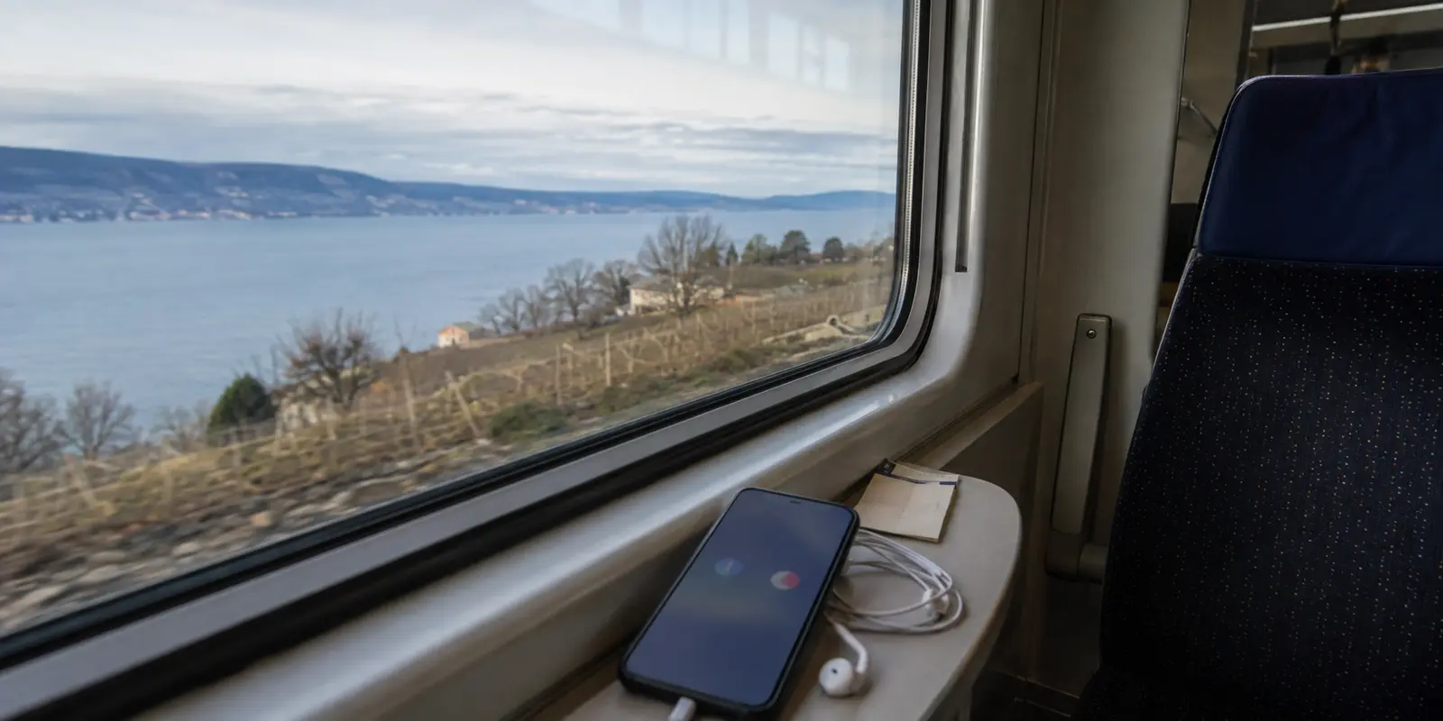 Téléphone posé dans un train longeant le lac Léman au passage de la frontière franco-suisse
