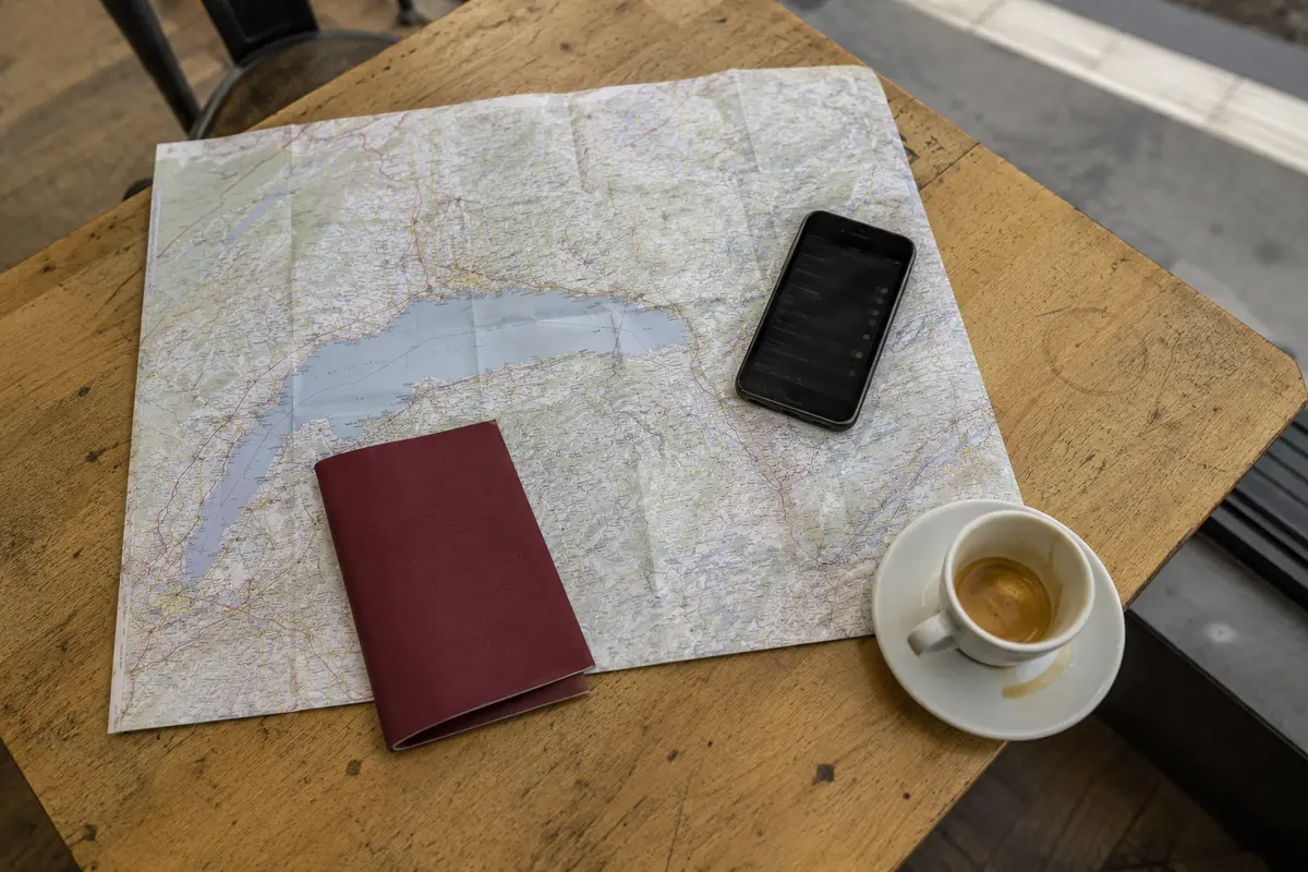 Carte de la région lémanique, téléphone et étui de transport sur une table de café