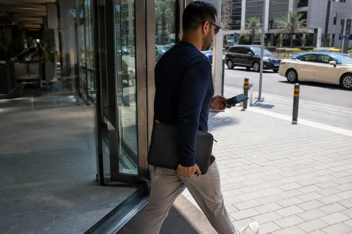 Un expatrié quitte un espace de coworking à Dubaï avec son téléphone et son ordinateur
