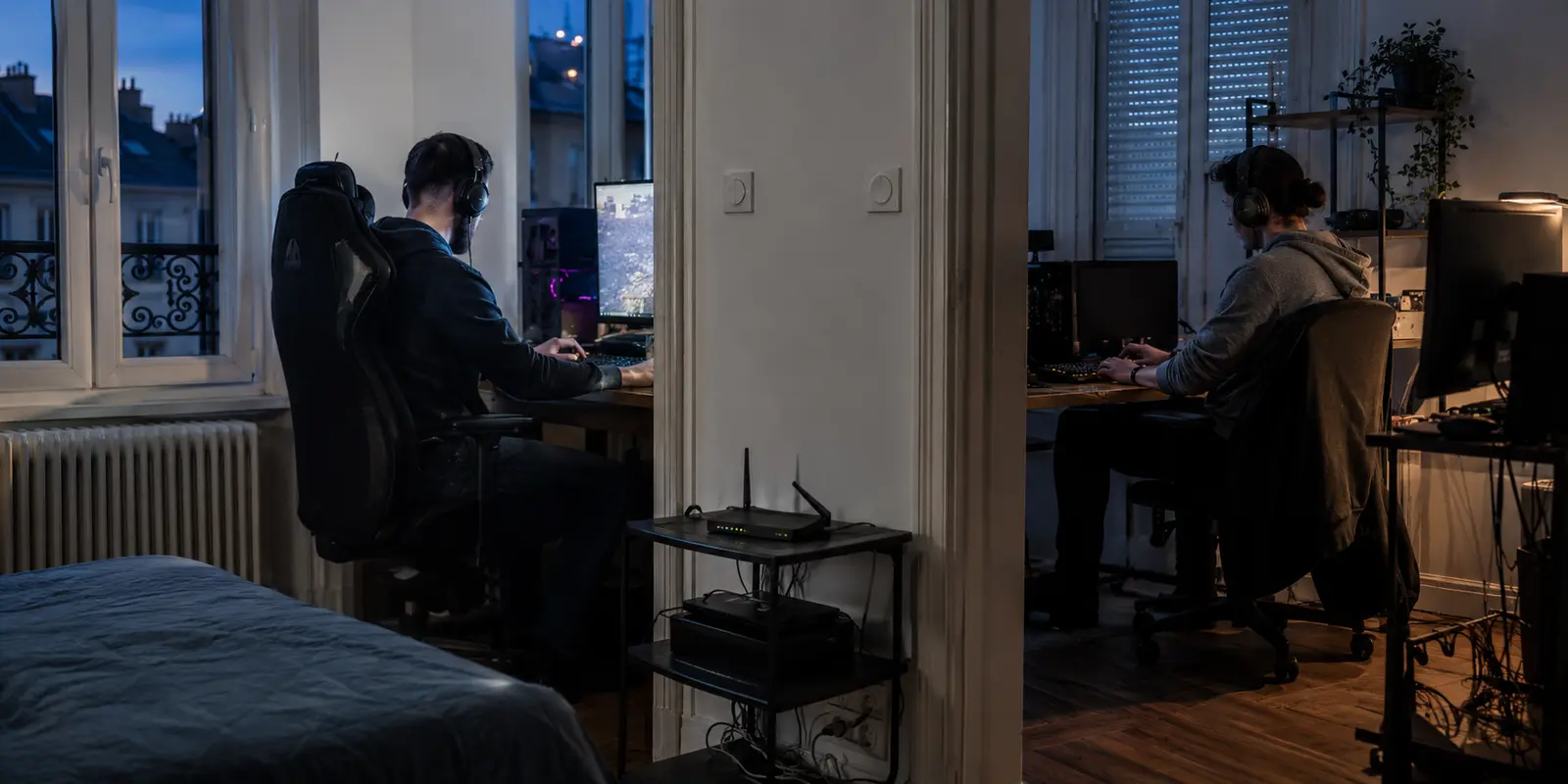 Deux joueurs utilisent chacun leur ordinateur dans deux pièces du même appartement, avec un routeur commun entre eux