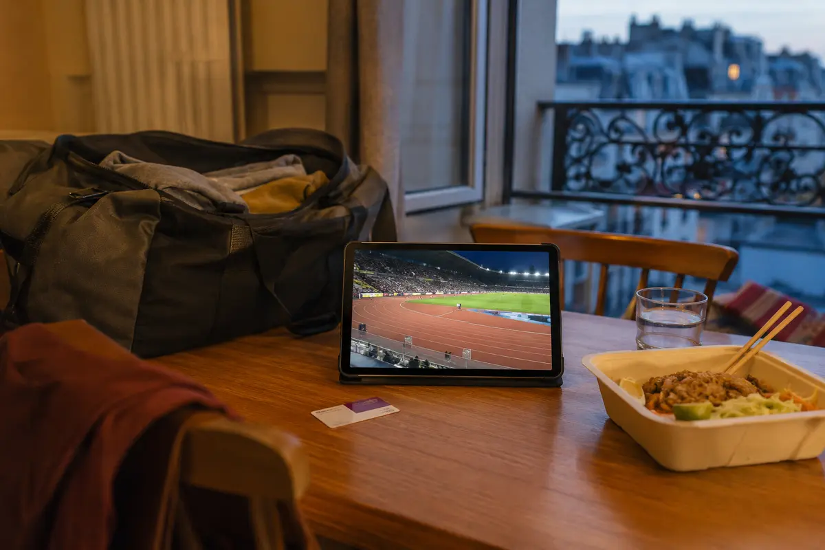 Compétition sportive regardée sur une tablette dans un logement temporaire