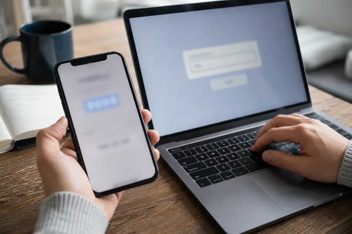 Un code de vérification affiché sur un téléphone sert à relier un ordinateur portable