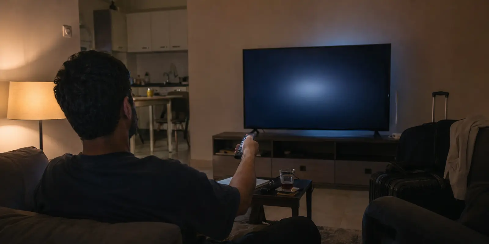 مشاهد ينتظر بدء البث على تلفزيون في شقة مؤقتة بالكويت