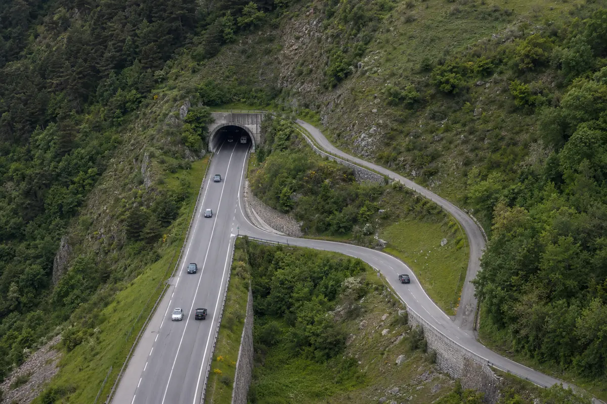 Route principale entrant dans un tunnel tandis qu’une voie locale le contourne