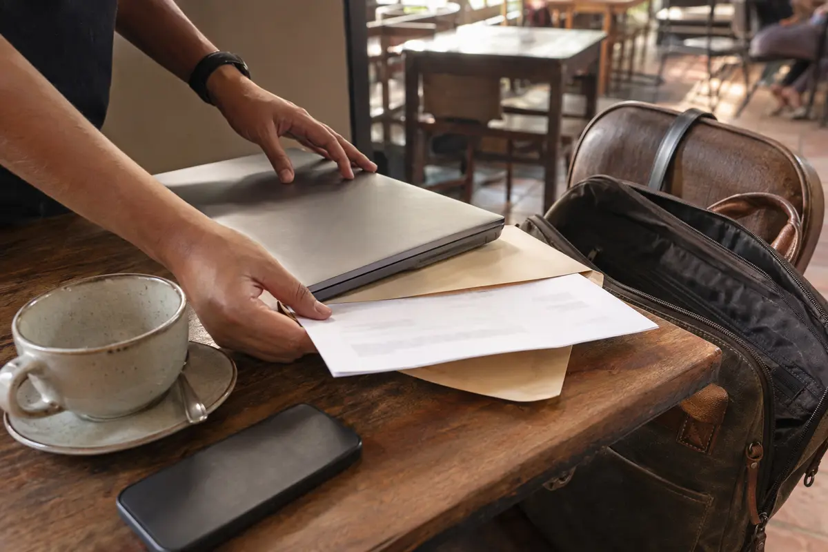 Un trabajador cierra el portátil y guarda una factura antes de salir de la cafetería