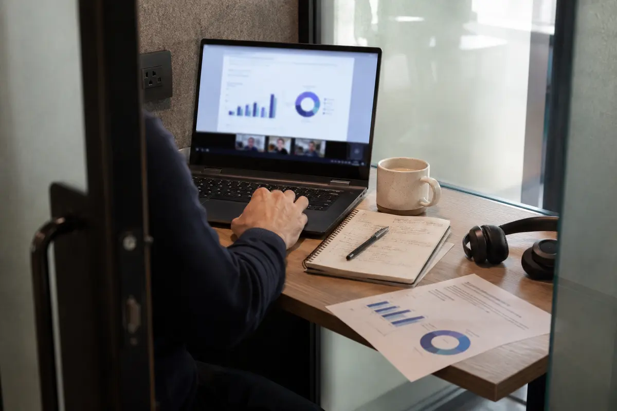 Profesional participando en una presentación remota desde una cabina de coworking