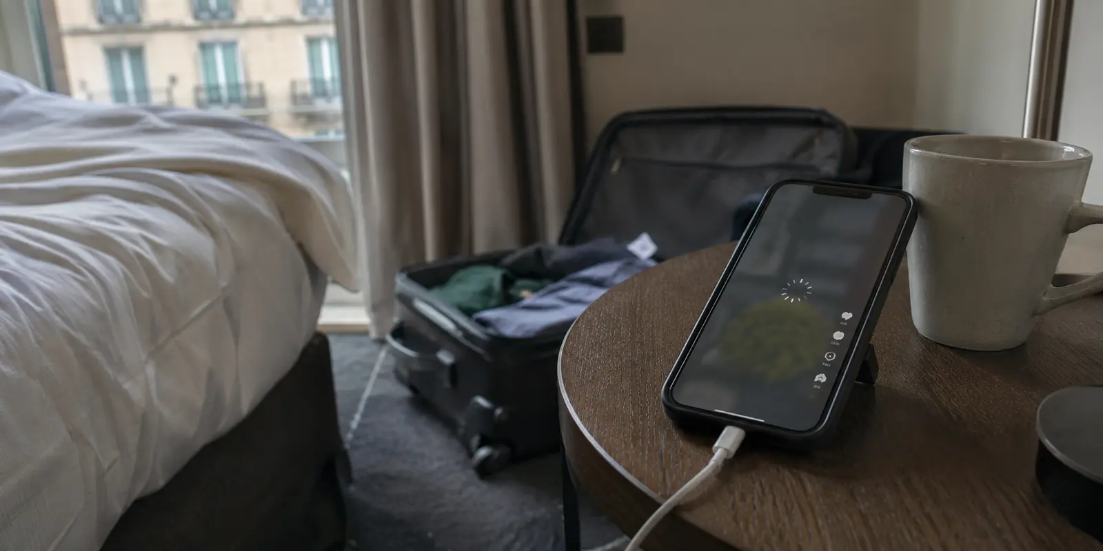 Un téléphone bloqué sur le chargement d’une vidéo TikTok dans une chambre d’hôtel