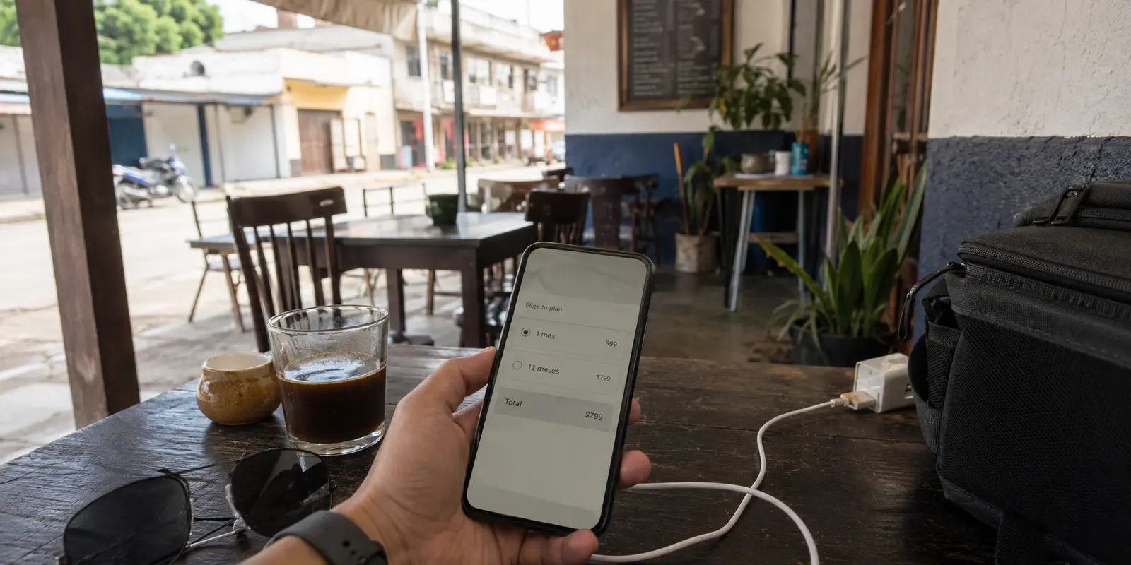 Una persona revisa en su teléfono el periodo y el total de una suscripción VPN desde una cafetería en México