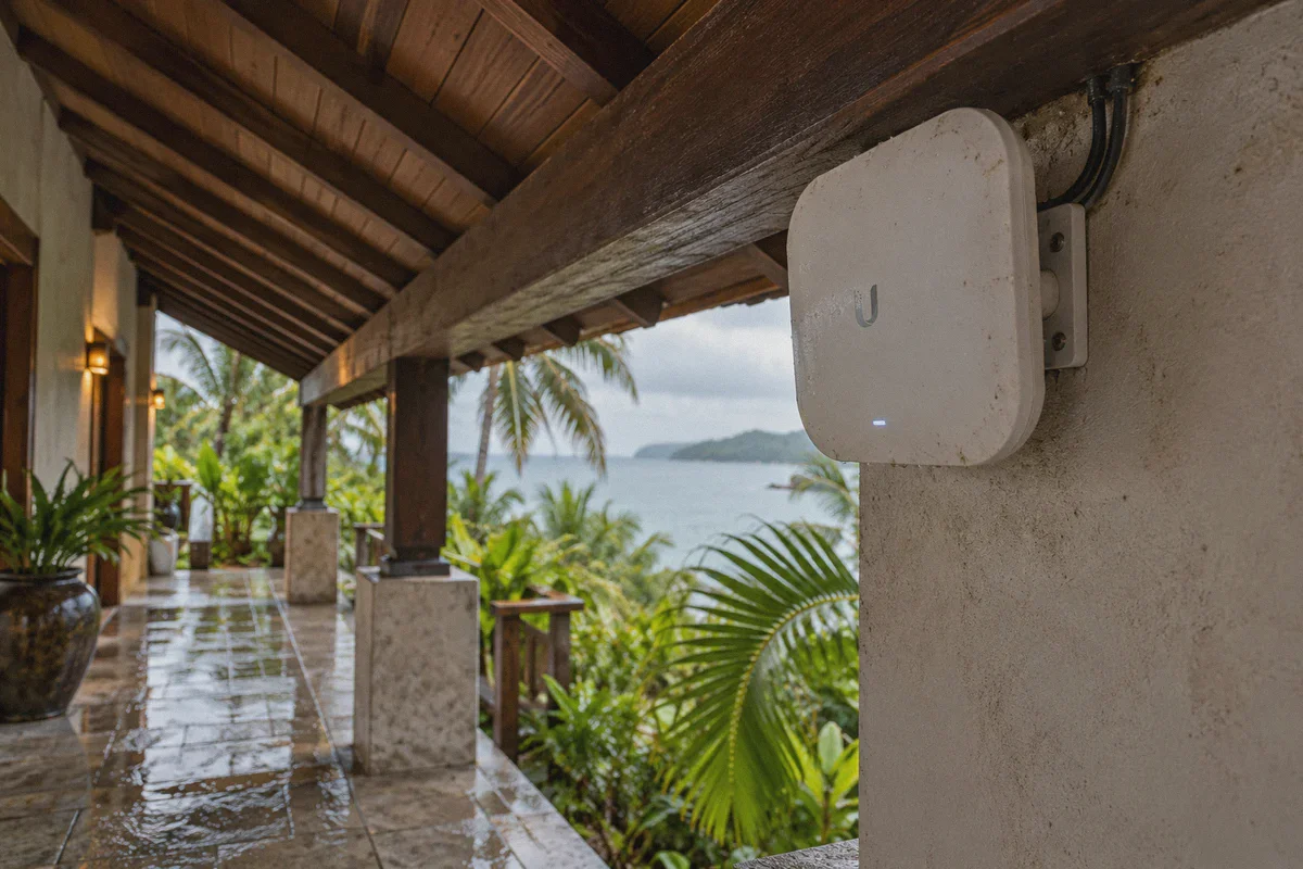 A guesthouse wireless access point beside an open tropical corridor.