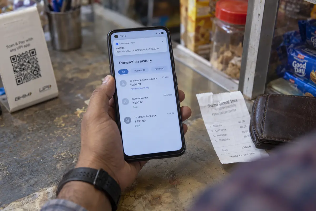 A customer checks a pending UPI transaction and bank message before deciding whether to pay again