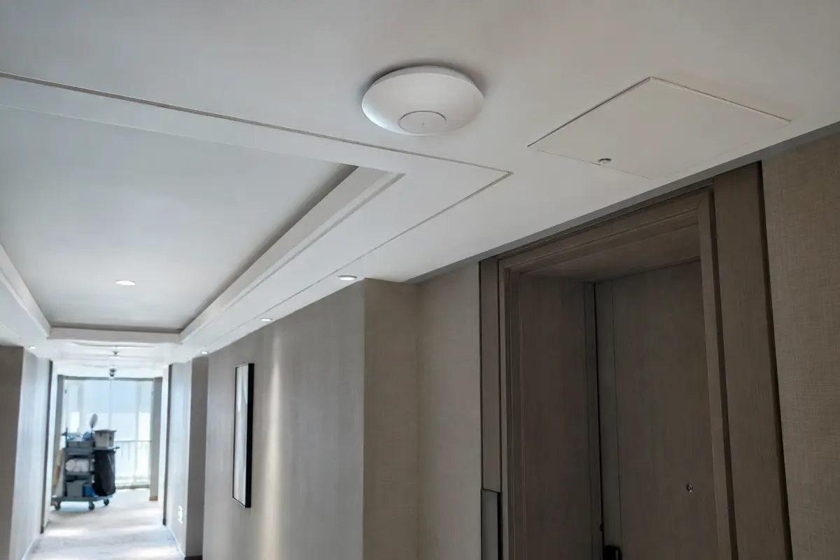 Punto de acceso Wi-Fi instalado en el techo del pasillo de un hotel