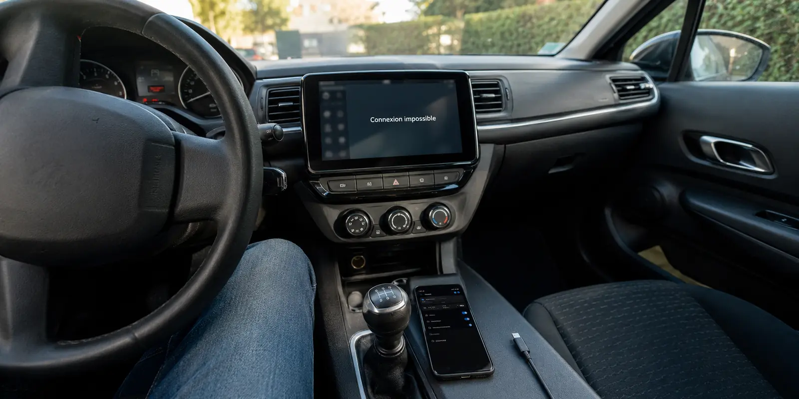 Dans une voiture à l’arrêt, l’écran affiche Connexion impossible alors que le téléphone reconnu reste débranché du câble USB.