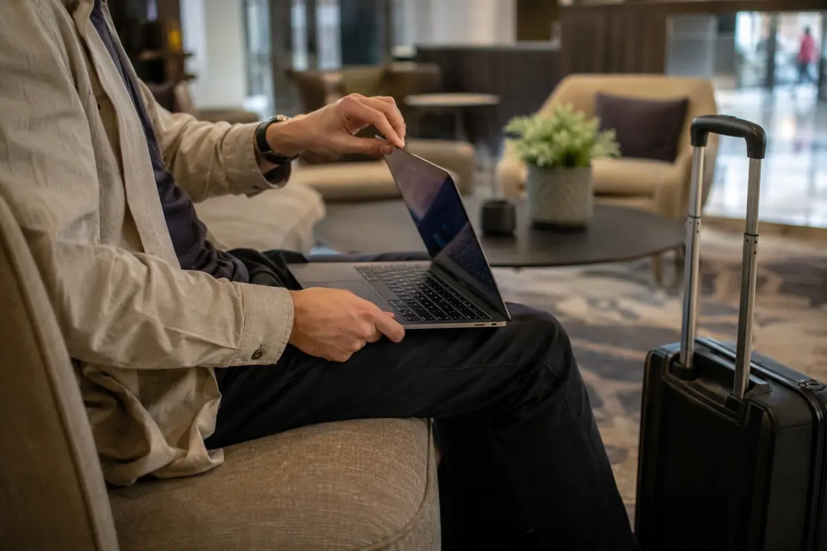 Viajante reabrindo o MacBook no lobby do hotel depois de mudar de rede