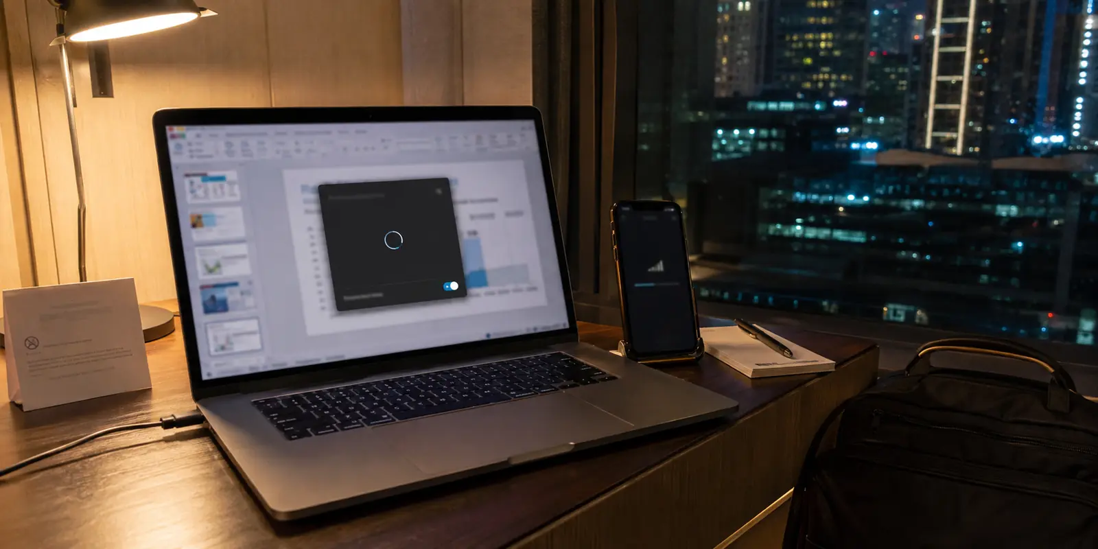 Un portátil en una habitación de hotel de Dubái muestra una VPN atascada mientras espera una presentación.