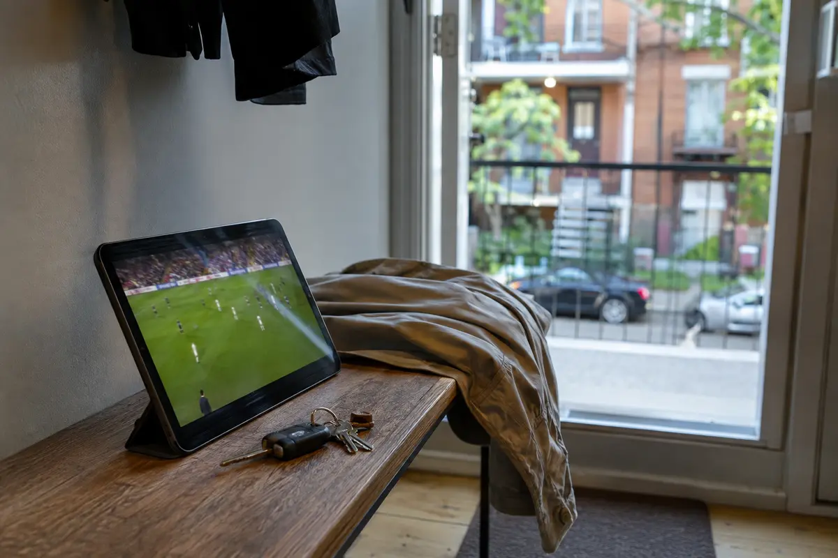 Le direct sportif démarre sur une tablette posée près des clés et de la veste
