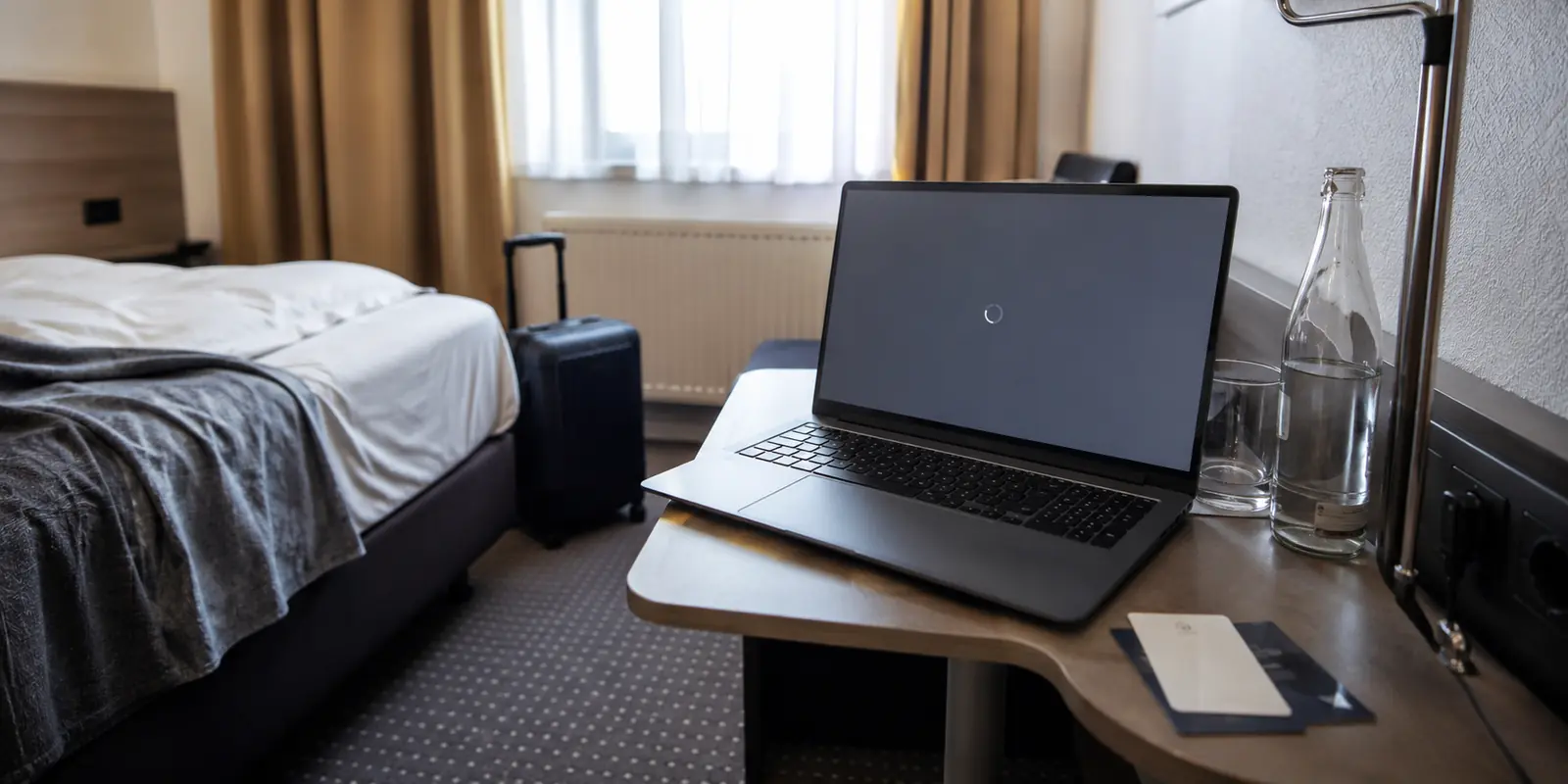 Geöffneter Laptop mit stockender Verbindung in einem Hotelzimmer am Morgen