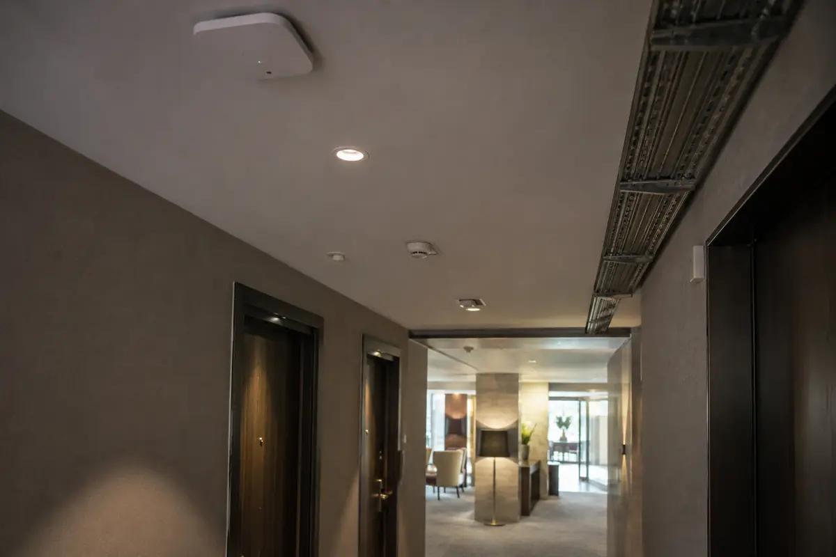 WLAN-Zugangspunkt an der Decke eines Hotelkorridors