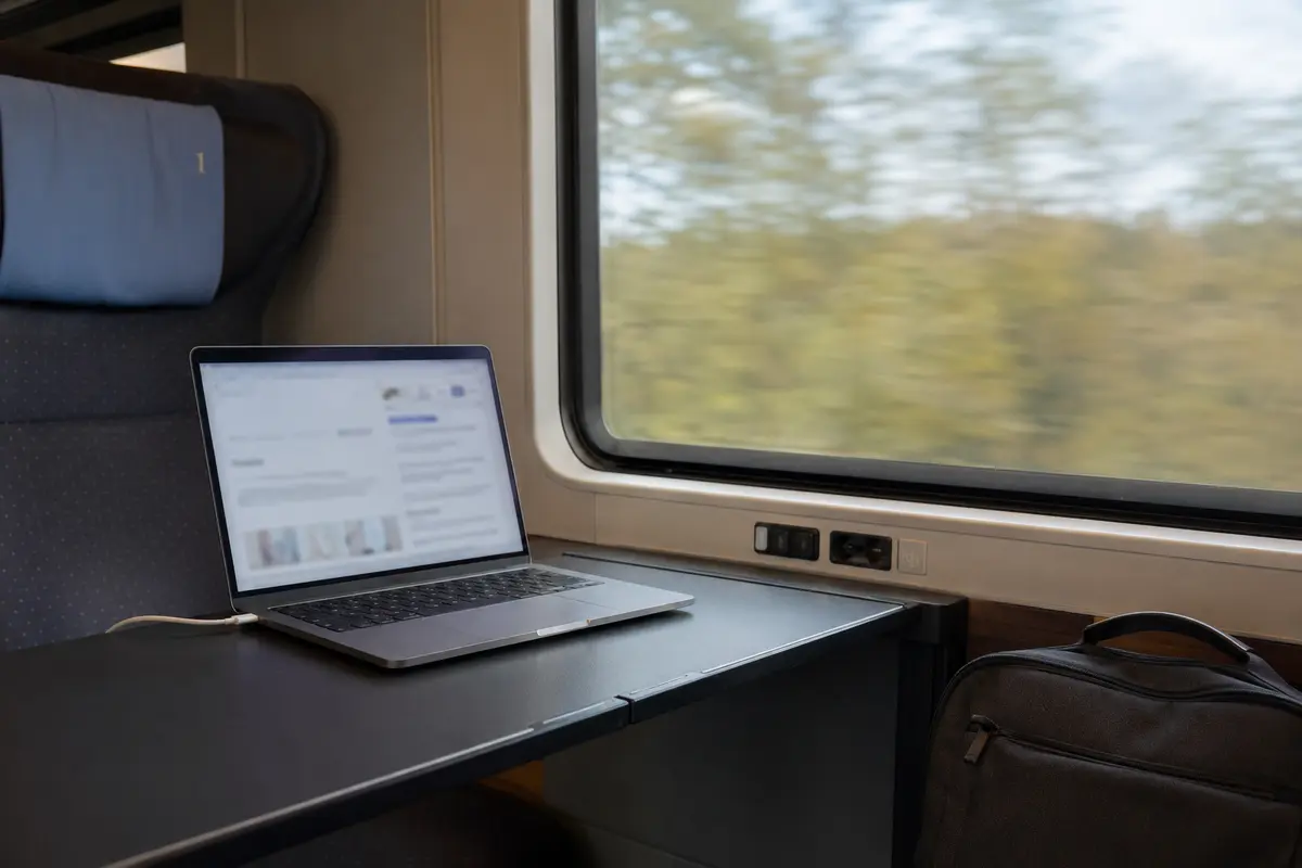 Laptop für alltägliche Online-Arbeit an einem Tisch im fahrenden Zug