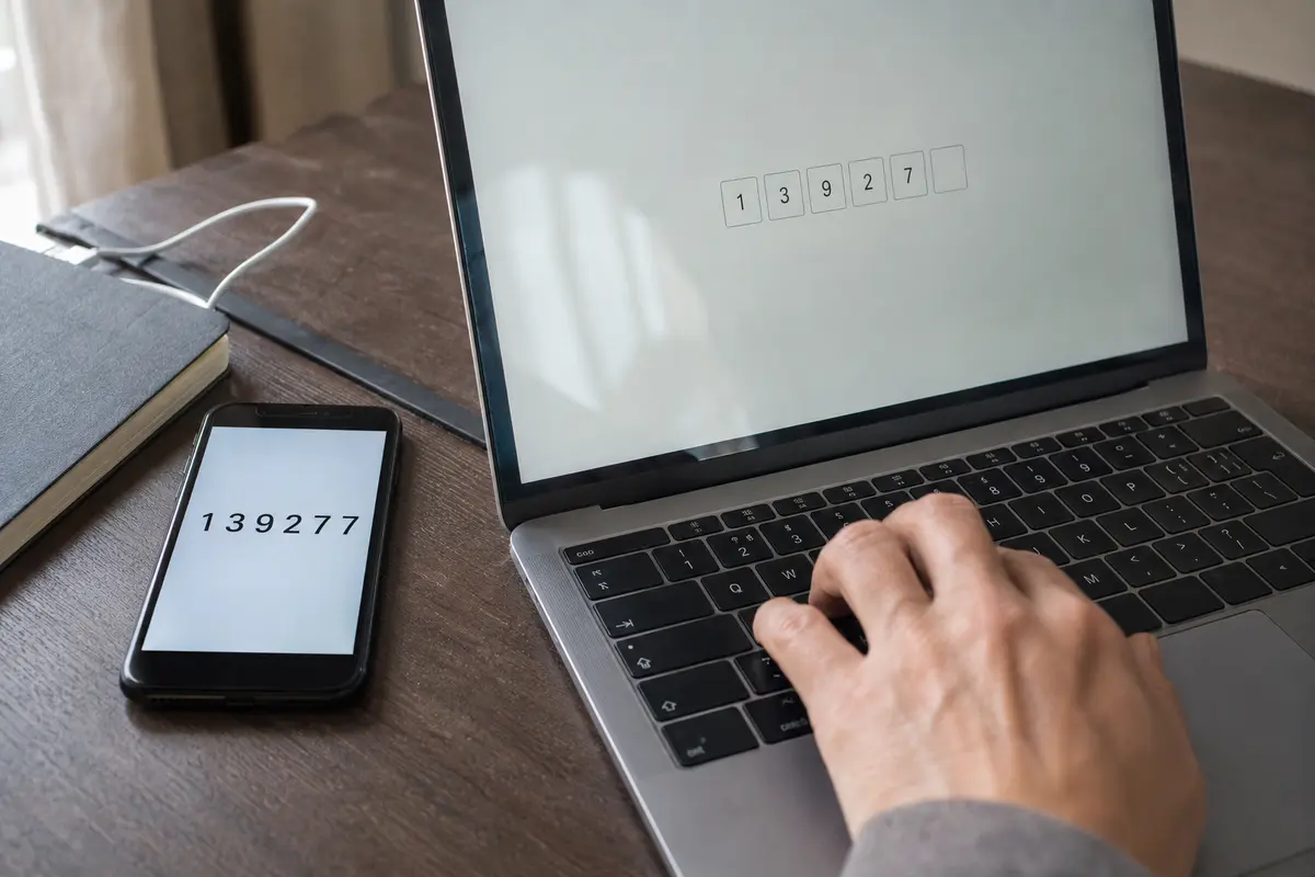 Un code affiché sur le téléphone est saisi directement sur l’ordinateur portable.