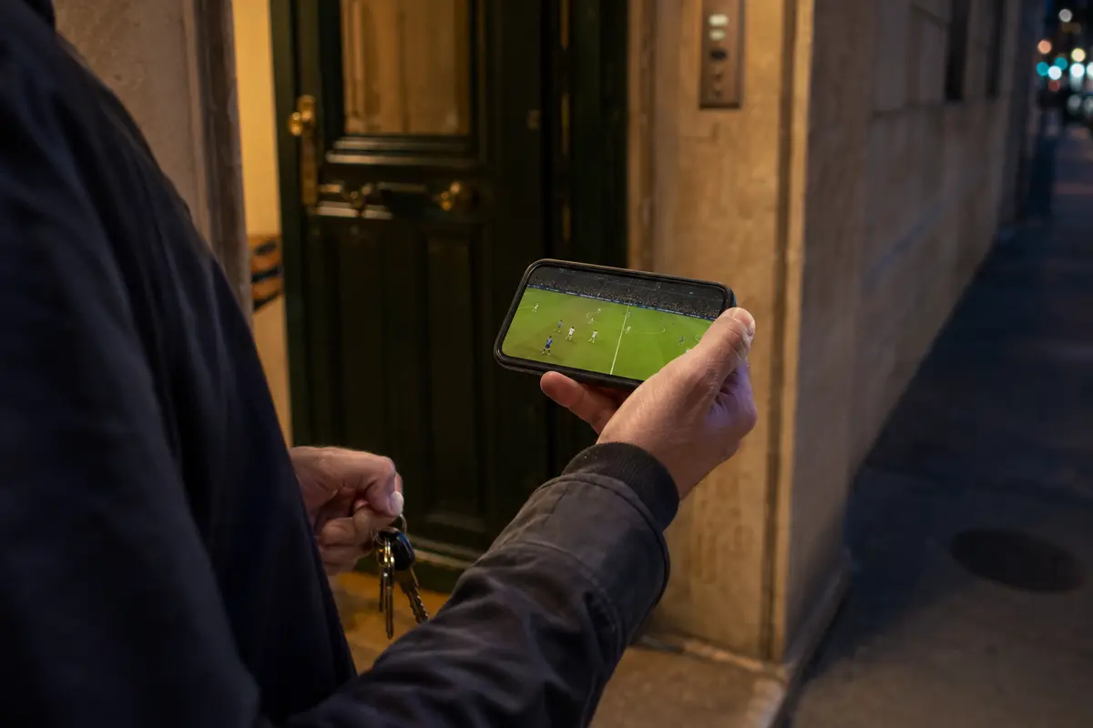 Match de football en direct repris sur un téléphone au moment de quitter l’appartement