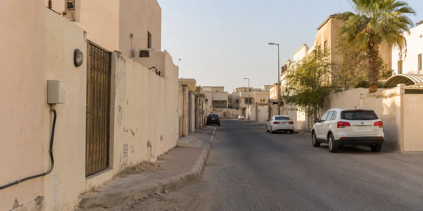 شارع سكني هادئ في البحرين مع صندوق اتصالات صغير على جدار منزل