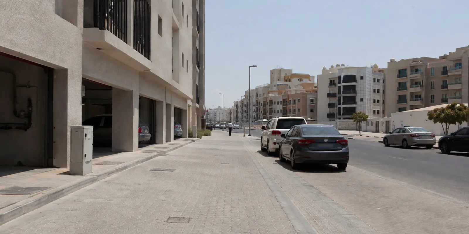 حي سكني عادي في دبي تحت شمس قوية وبجواره خزانة اتصالات صغيرة