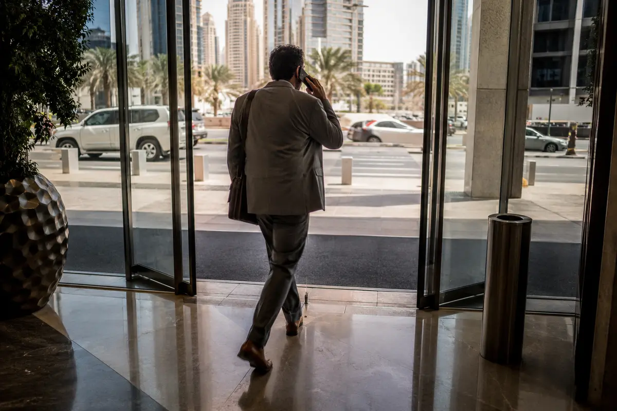 مسافر يواصل مكالمته أثناء خروجه من فندق في دبي