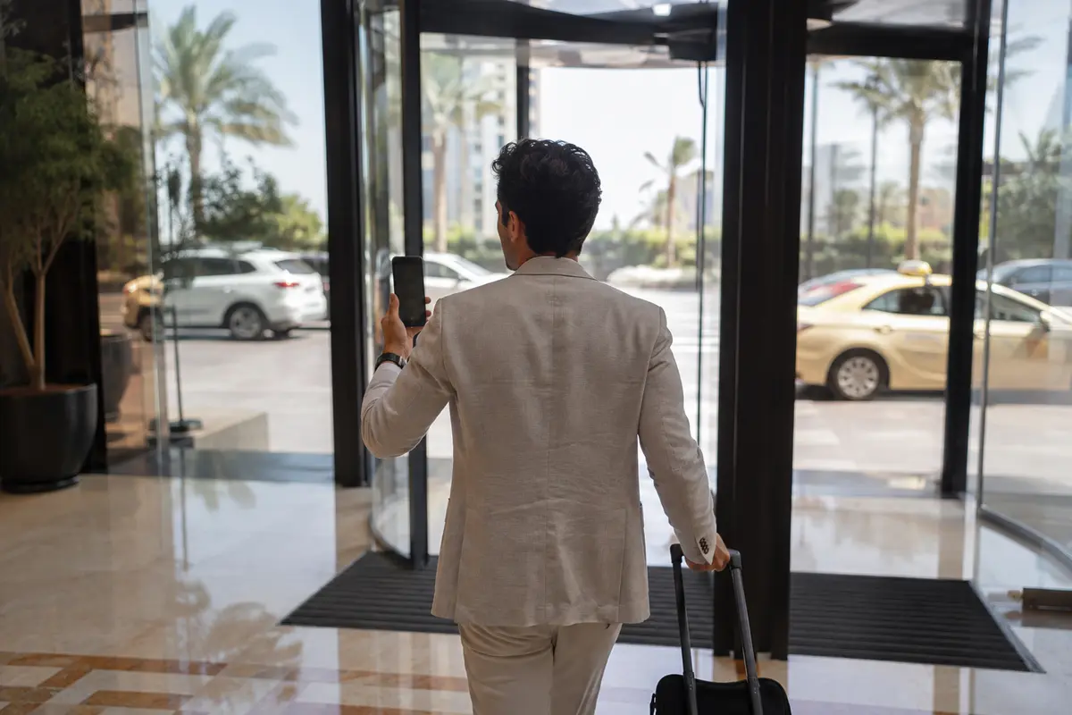 مسافر يواصل مكالمة أثناء خروجه من فندق في دبي