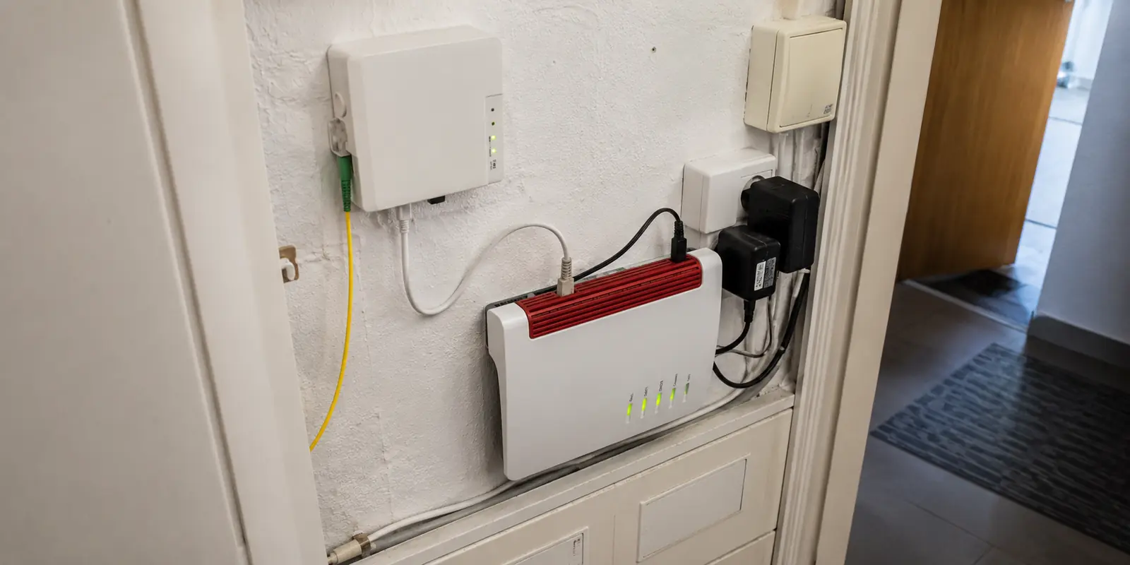 Glasfaserabschluss und Heimrouter in einer kleinen Hausanschlussnische