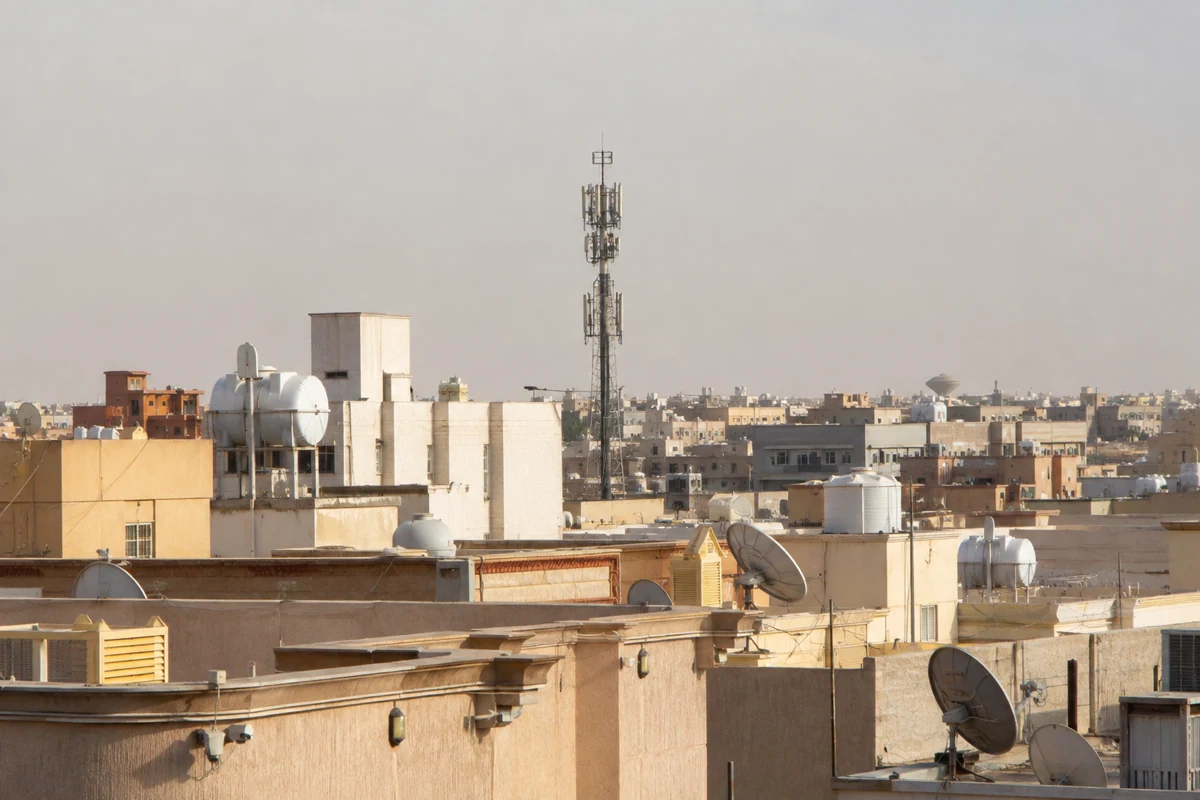 برج اتصالات خلوي يرتفع بين أسطح حي سكني في الرياض