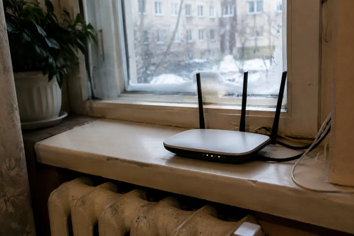 موجّه Wi-Fi منزلي على حافة نافذة متجمدة في شقة بموسكو