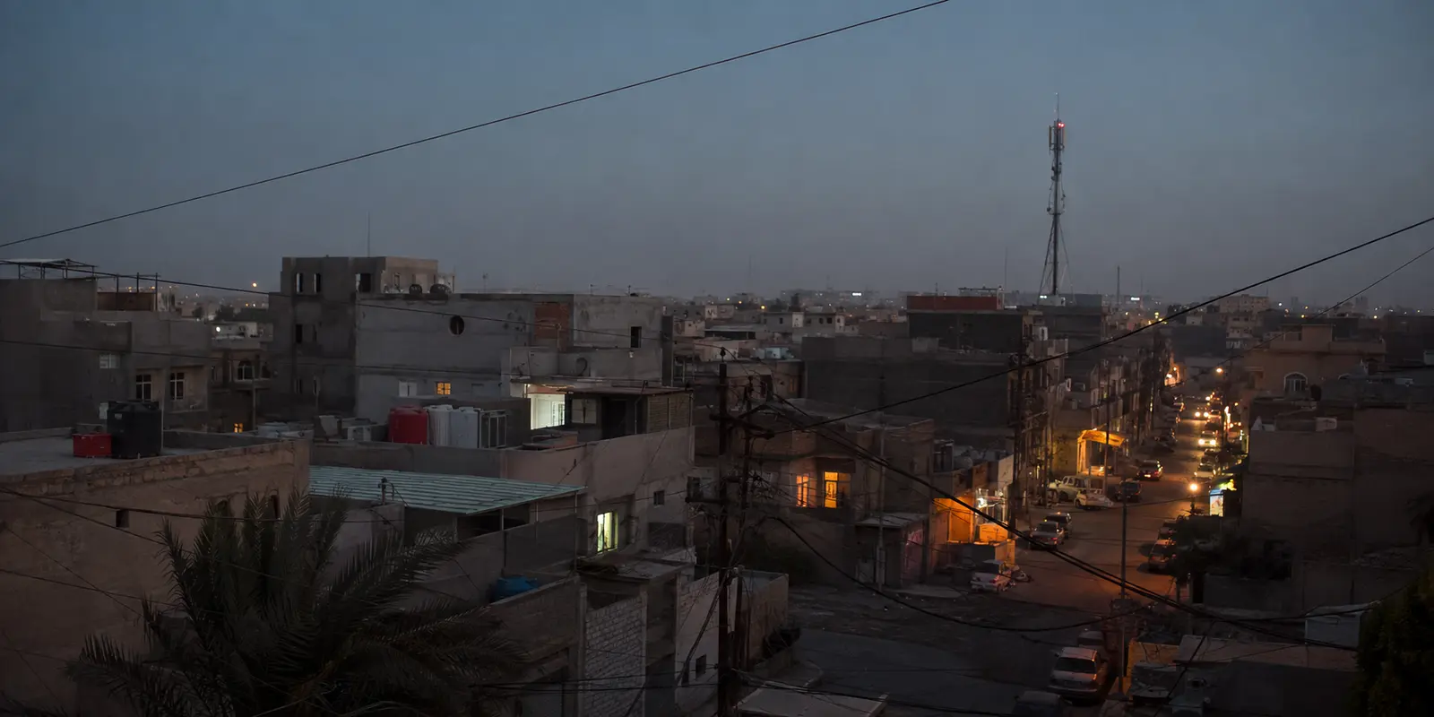شبكات الاتصالات فوق حي سكني في بغداد عند المساء
