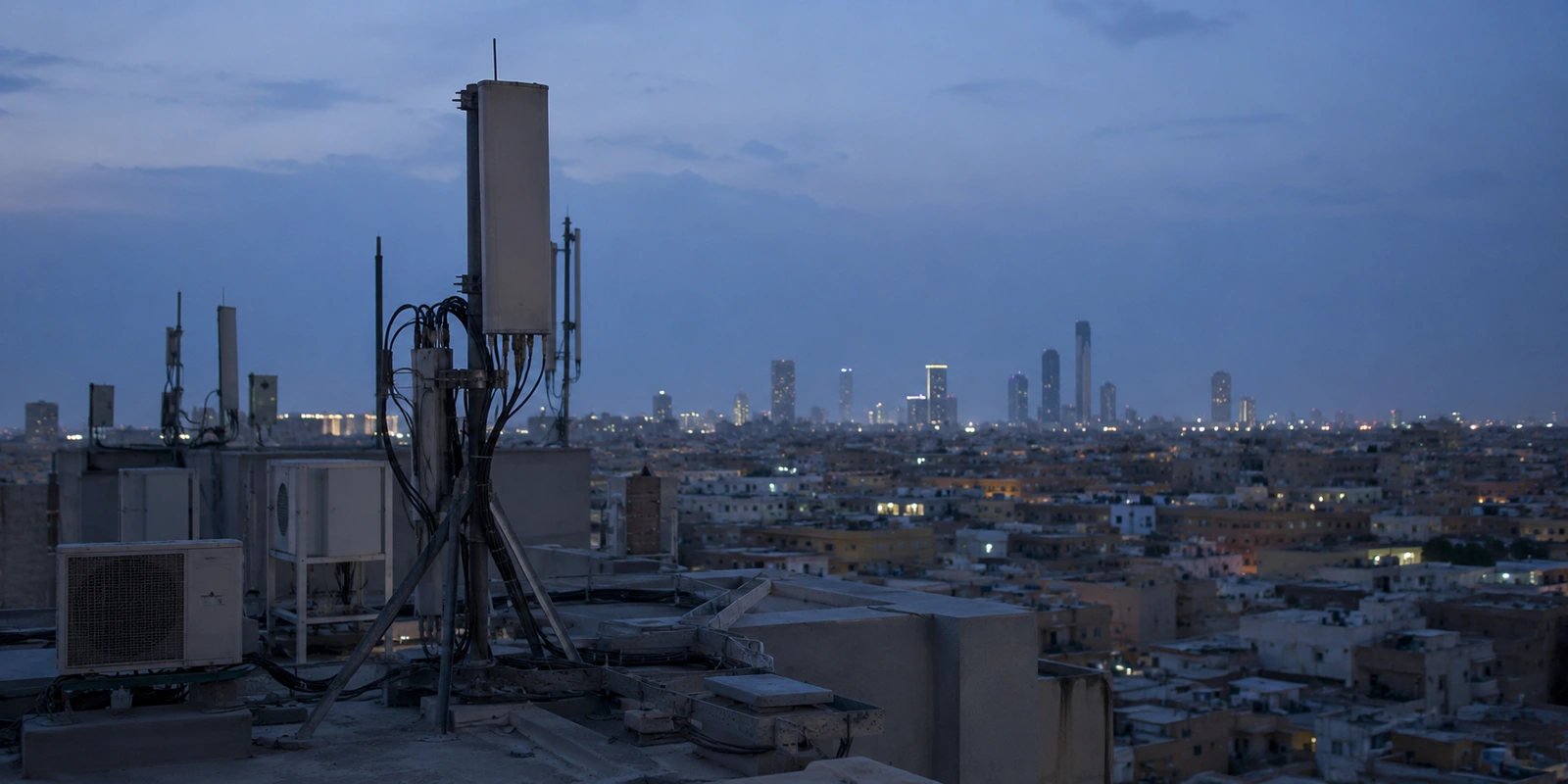 معدات اتصالات على سطح مبنى تطل على الرياض عند المساء